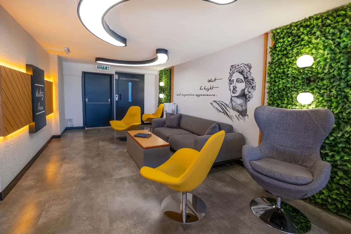 Waiting lounge with yellow armchairs and a green wall