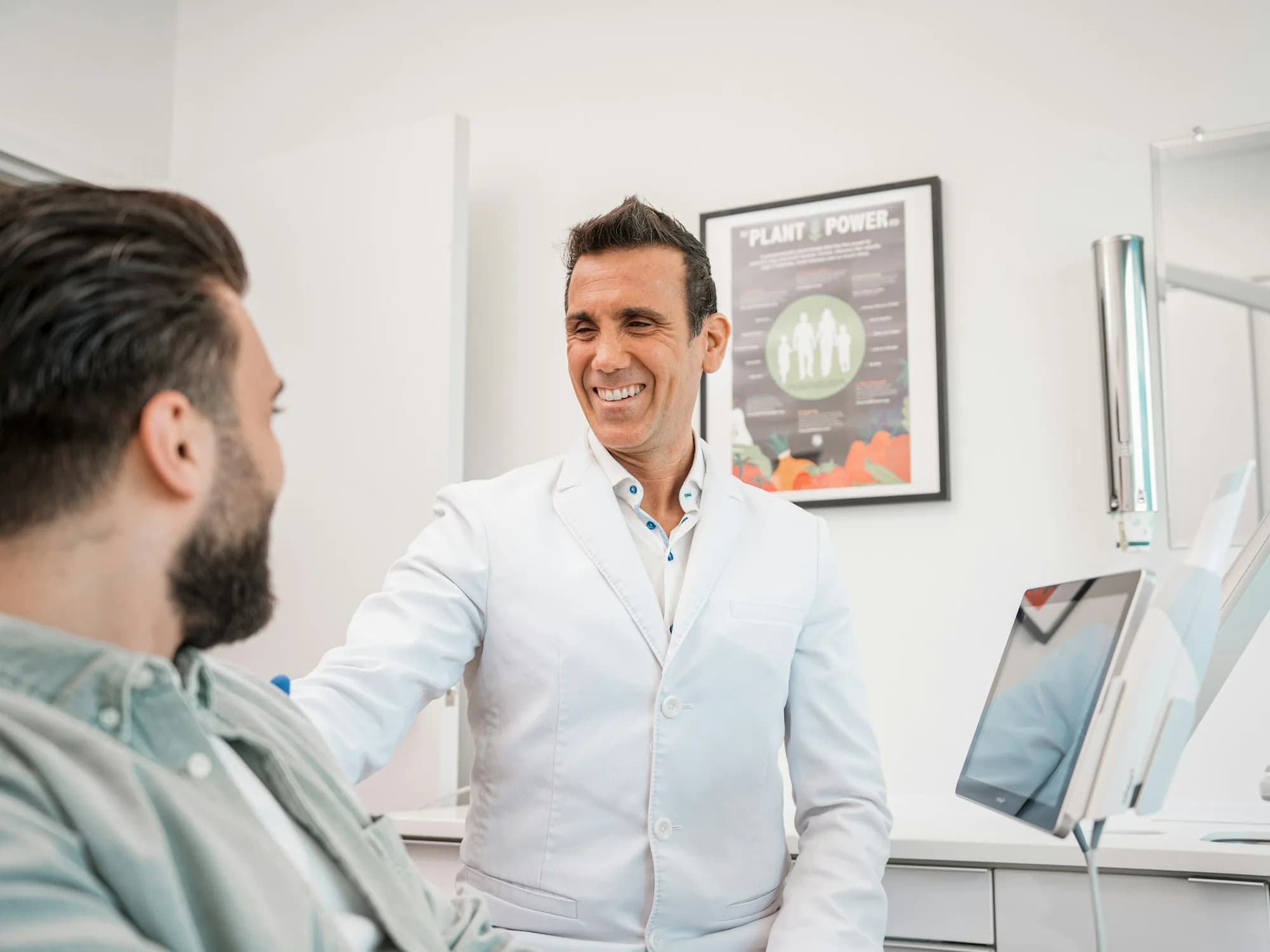 Smiling dentist chatting with a patient in the treatment chair