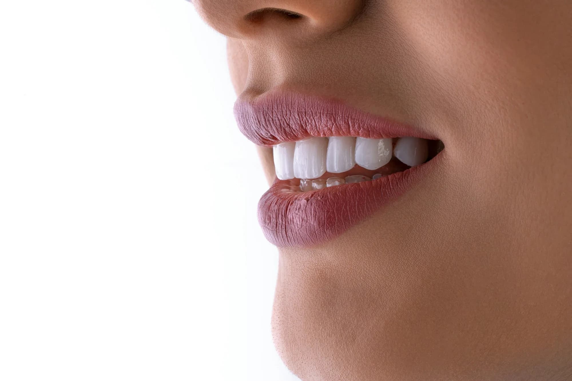 Side close-up of a smile showing even white teeth